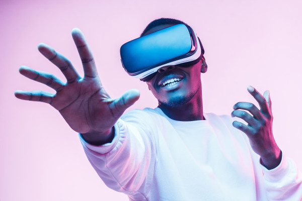 Ein Mann mit VR Brille er spielt etwas und lächelt