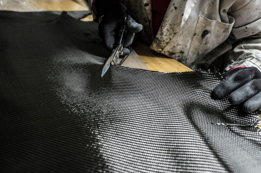 Ein Carbon Teppich welcher mit einer Schere geschnitten wird