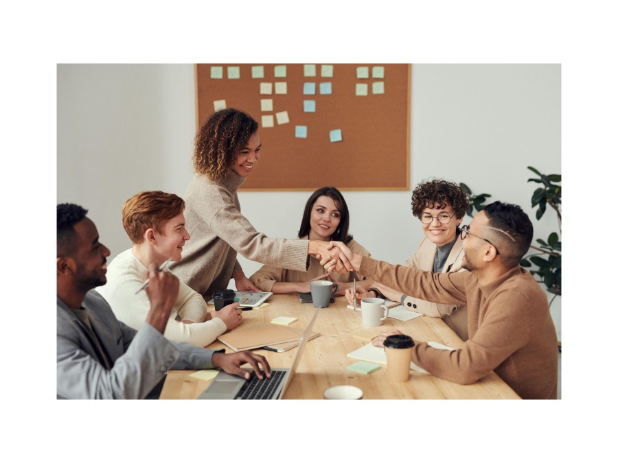 Image of a group of people where two of them shake hands.