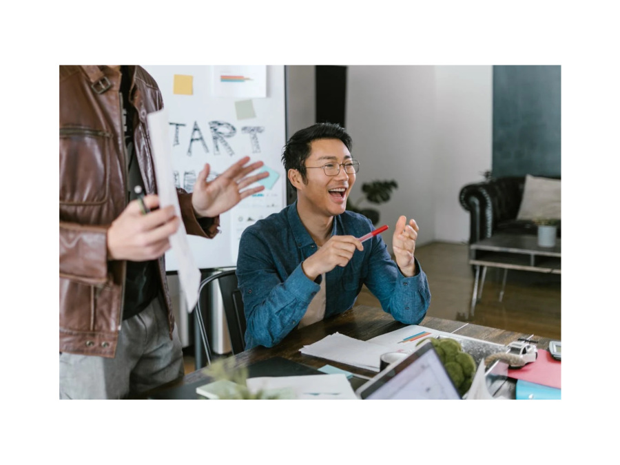 Image of Two People in a Meeting Room collecting Ideas while one of tem looks happy and holds a red pen