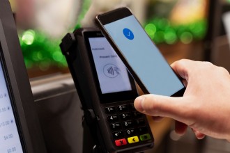 Picture of a person paying contacless with their phone